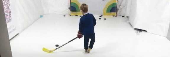 Child shooting pucks on a RapidShot system